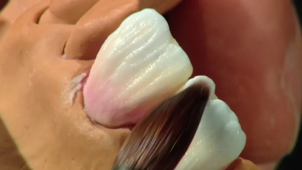 A ceramist layering porcelain over a pressed lithium disilicate core