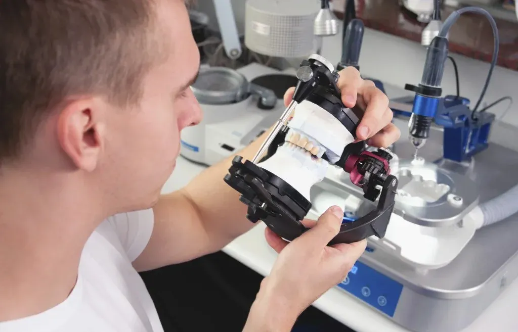 A technician checking zirconia crowns on the model before shipping